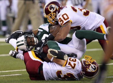 New York Jets wide receiver Braylon Edwards, center, is tackled by Washington Redskins' LaRon Landry (30) and Reed Doughty (37) last season. The sides are slated to meet on 11 September.