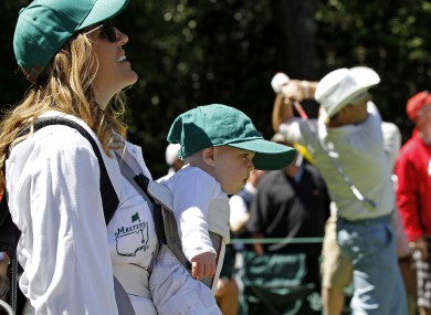 Early start: Amy and son Bodie watch as husband Rory Sabbatini tees off during the Par 3 competition last evening.