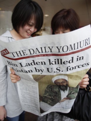 Women reads the extra edition of a Japanese newspaper in Tokyo Monday, May 2, 2011, reporting the death of Osama bin Laden.