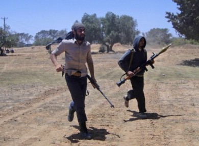 Rebel fighters run during heavy fighting with pro-Gadhafi forces on the frontline of Dafniya 40 km west Misrata, Libya, Sunday, June 12, 2011.