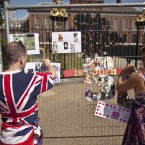 Kathy Martin and John Loughrey put up their Princess Diana 50th birthday tributes on fencing outside Kensington Palace in London (AP Photo/Matt Dunham)