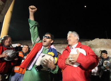 Luis Urzua (left), the last of the miners to be rescued, sings the national anthem with Chilean president Sebastian Pinera.