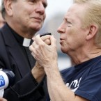 Bob Kriesat, left, and his partner Ed Mather interlock hands as they hold on to the mic of a loud speaker during a gay marriage rally at Pier A Park, yesterday in Hoboken, New Jersey. The couple and others at the rally asked New Jersey officials to pass a law allowing same-sex marriages in the state similar to that in New York. (AP Photo/Julio Cortez)