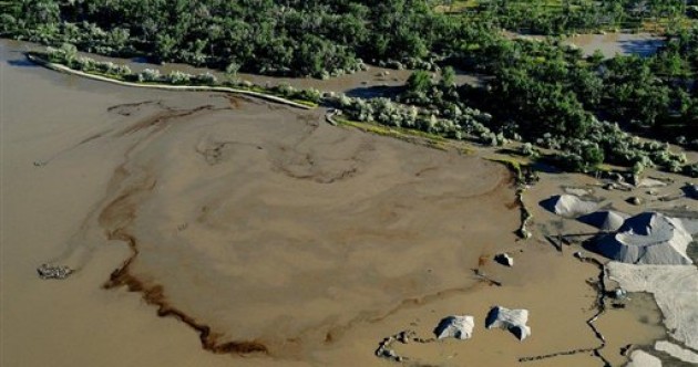 Oil swirls in a flooded gravel pit in Lockwood, Montana after crude oil pipeline ruptures in river.