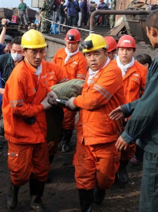 In this photo released by China's Xinhua News Agency, rescuers carry a miner out of a flooded mine in Qitaihe, northeastern China, Tuesday, Aug. 30, 2011.