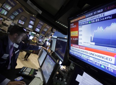 A television screen at the post of specialist Stephen Ruiz, left, displays the decision of the Federal Reserve, on the floor of the New York Stock Exchange