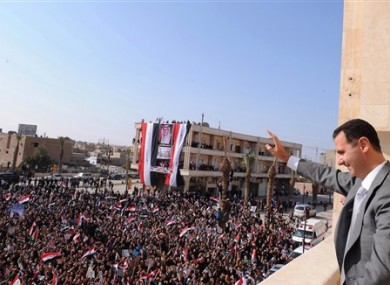 In this photo released by the Syrian official news agency SANA, Syrian President Bashar Assad, right, waves to his supporters on Sunday, Nov. 6, 2011