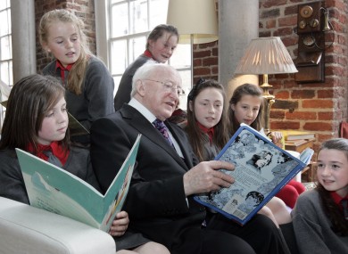 President Michael D Higgins reads a book by Oscar Wilde to schoolchildren at The Ark, Dublin.