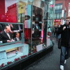 Minister for Finance Michael Noonan's delivery of his Budget to the Dail is shown on TV in the Philips Shop on Georges Street in Dublin, as members of the public pass by. Photo Leon Farrell/Photocall Ireland