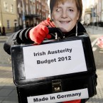 A protestor dressed as German Chancellor Angela Merkel outside Leinster House in Dublin as Finance Minister Michael Noonan prepared to announce the second half of the Budget 2012 detailing major tax reforms. Photo: Niall Carson/PA Wire