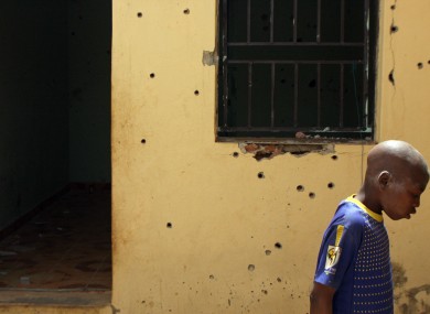 A boy looks at bullet holes in the compound where the two hostages were held in Sokoto, Nigeria.