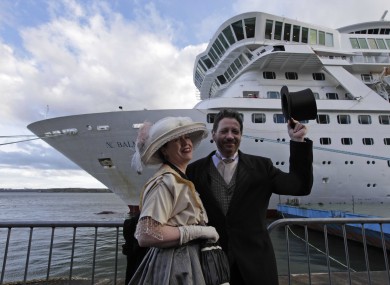 Passengers from the cruise pose in front of the vessel