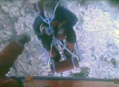 This framegrab image provided by the U.S. Coast Guard shows one of three crew members from the yacht Low Speed Chase being rescued from the Farallon Islands west of San Francisco