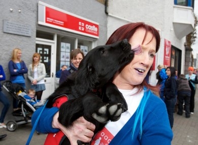 Assistance puppy dog 'Skye' gives Breeda Clancy of AADI a big kiss turning Mallow Blue for World Autism Awareness Day at the Autism Assistance Dogs of Ireland HQ.