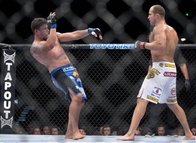 Frank Mir, left, falls backward after Junior Dos Santos landed a punch in the second round.