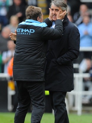 Manchester City manager Roberto Mancini celebrates with one of his backroom staff.