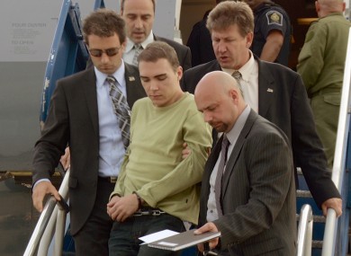 Luka Rocco Magnotta is taken by police from a Canadian military plane to a waiting van in Quebec on Monday
