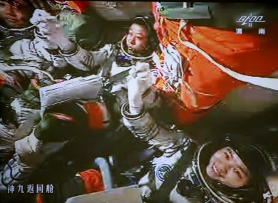 The three astronauts celebrate after the successful docking between the spacecraft and the lab module