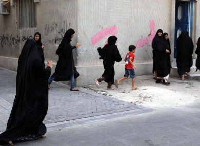 Women and children run as riot police, unseen, chase Bahraini anti-government protesters