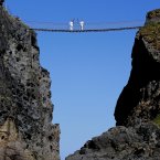 The Olympic Flame is carried across the famous landmark of the Carrick-a-Rede rope bridge outside the village of Ballintoy, Co. Antrim by carriers Clare Leahy and Denis Broderick.