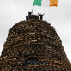 Children stand on a bonfire in the Shankill Estate (AP Photo/Peter Morrison)
