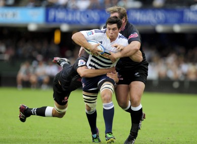 Keegan Daniel of the Sharks and team mate Jannie du Plessis tackle Francois Louw.