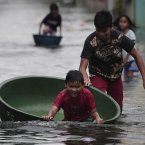 A Filipino boy plays along a flooded street in Obando town, Bulacan province, north of Manila today. (AP Photo/Aaron Favila/PA)
