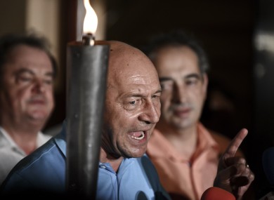 Suspended Romanian President Traian Basescu holds a torch while speaking at the end of the referendum on Romania's president impeachment day