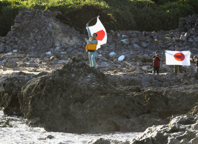 Japanese activists hold their national flag on Uotsuri island, one of the islands which is also claimed by China and Taiwan.