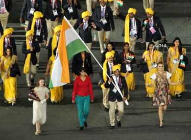 Madhura Nagendra, pictured in red, walks alongside India's Sushil Kumar as he carries the flag the athletes' parade.
