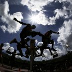 Athletes clear a barrier in a men's 3000-meter steeplechase heat during the athletics in the Olympic Stadium at the 2012 Summer Olympics, London, Friday, Aug. 3, 2012. (AP Photo/David J. Phillip)