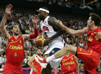 LeBron James drives between Spain's Pau Gasol and Rudy Fernandez.