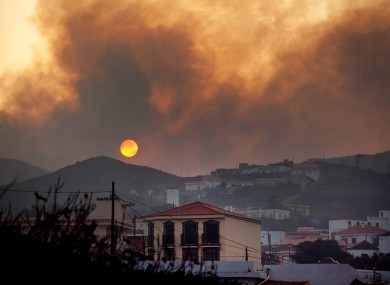 Smoke billows across houses as a wildfire burns near Chipude Village, La Gomera, Spain