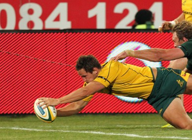 ustralia's Mike Harris, left, scores a try as South Africa's Andries Bekker attempts a tackle.