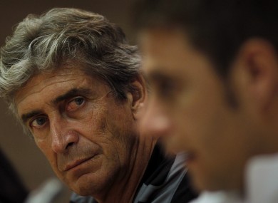 Malaga's coach Manuel Pellegrini, listens to Joaquin Sanchez at the Rosaleda stadium yesterday.