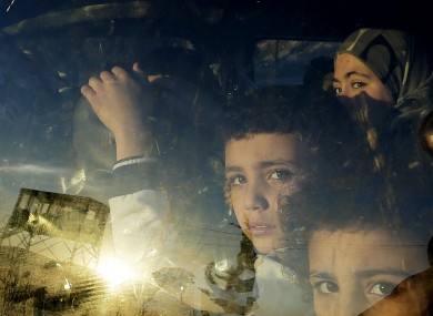 Syrian children look through their car window as they cross into Lebanon with their families at the border crossing, in Masnaa, eastern Lebanon