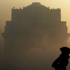 An Indian Army soldier in ceremonial dress stands guard as the India Gate monument is shrouded in heavy fog prior to a dress rehearsal for the annual Republic Day parade in New Delhi, India. (AP Photo/Kevin Frayer)