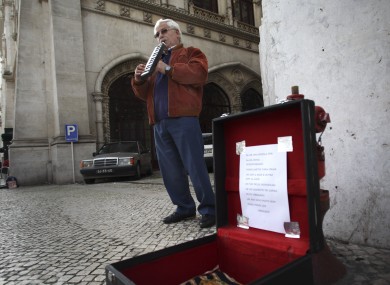 Jose Fonseca, 62, who has been unemployed for six months, plays music on the street for money in downtown Lisbon, earlier today.