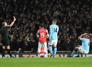 Match referee Mike Dean (left) sends off Manchester City's Vincent Kompany (right).