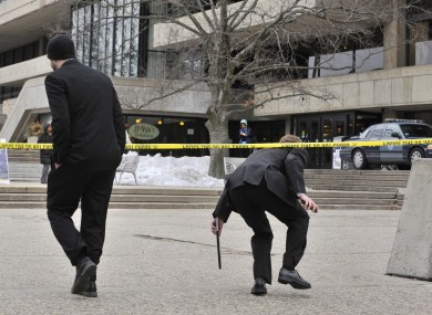 Pedestrians on the MIT Campus in Cambridge, Mass., duck underneath police tape