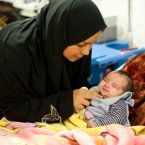 A mother cares for her child at a Red Cross Red Crescent field hospital in Mafraq, Jordan, where injured and sick Syrian refugees are being treated for shrapnel and bullet wounds along with illnesses.
Photo: Kenneth O'Halloran, Irish Red Cross