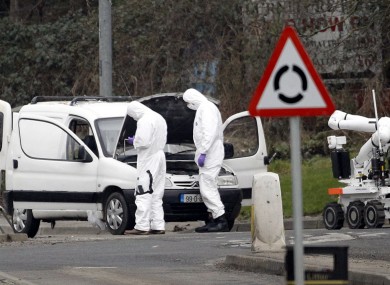 Police forensic officers examine a car in which four mortar rounds were found in Derry today